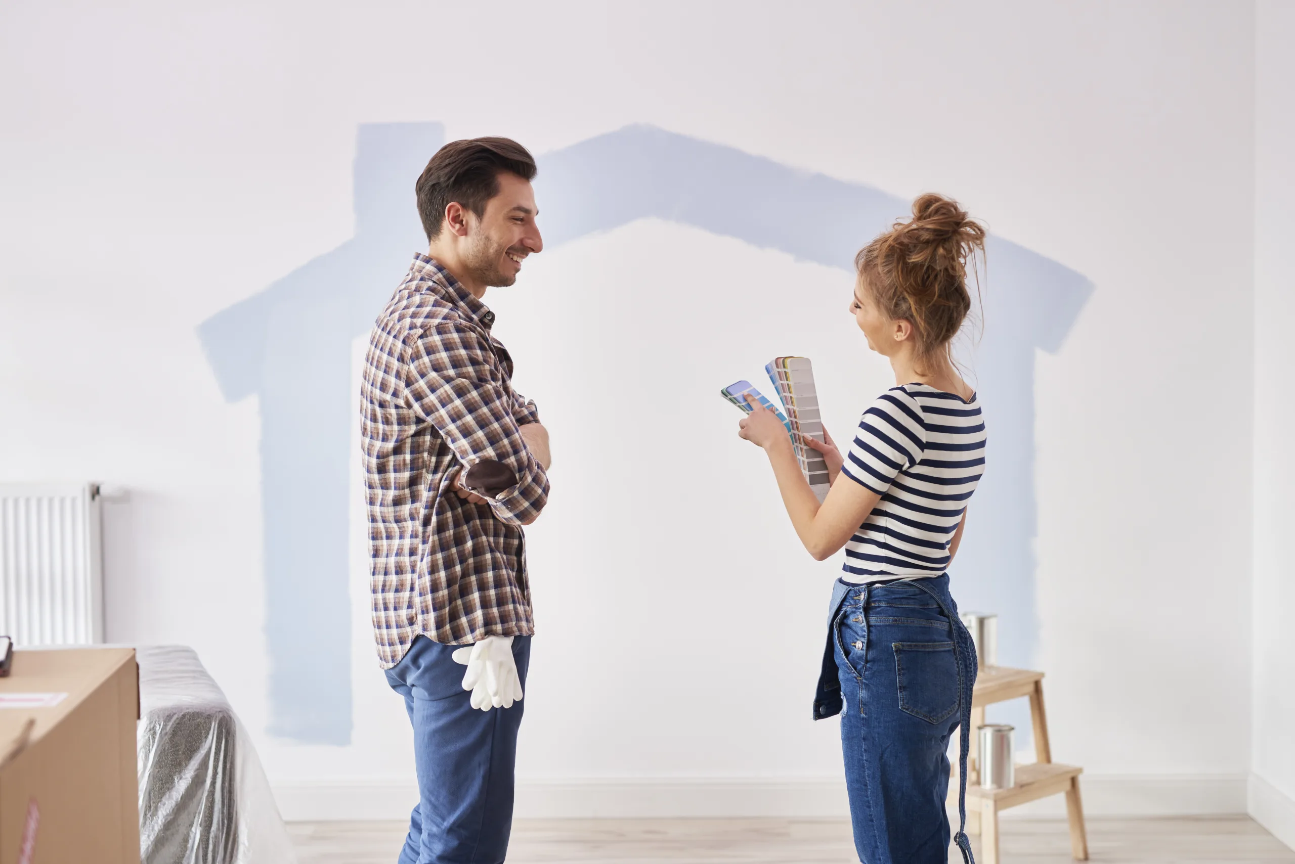 Couple painting the interior wall in their new apartment